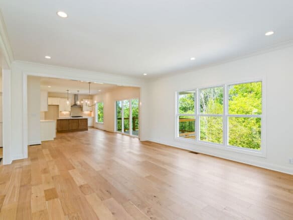 Spacious living area with large windows and hardwood floors in a modern home.