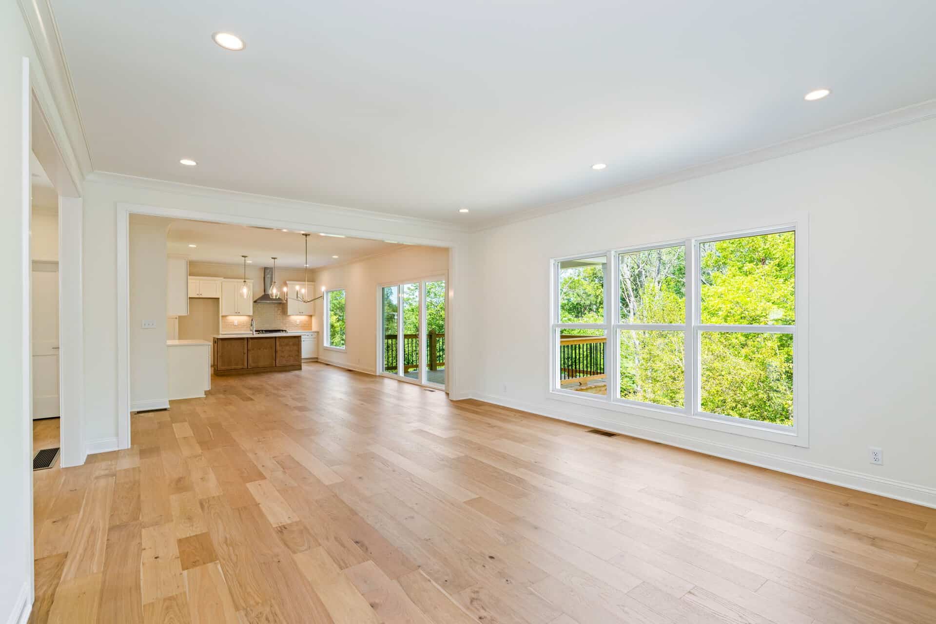 Spacious living area with large windows and hardwood floors in a modern home.
