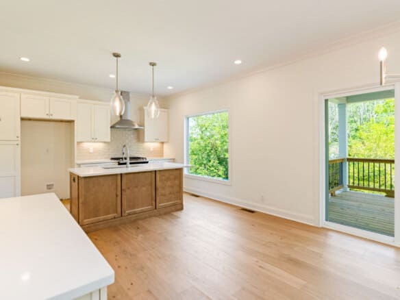 Bright open kitchen and dining area with large windows and sliding door to deck.