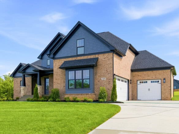Luxury modern home with brick and blue siding exterior and attached garage.