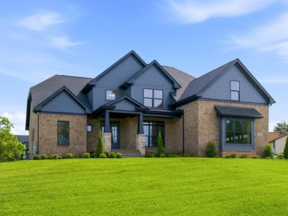 Modern luxury home with blue siding and brick accents in Kentucky.