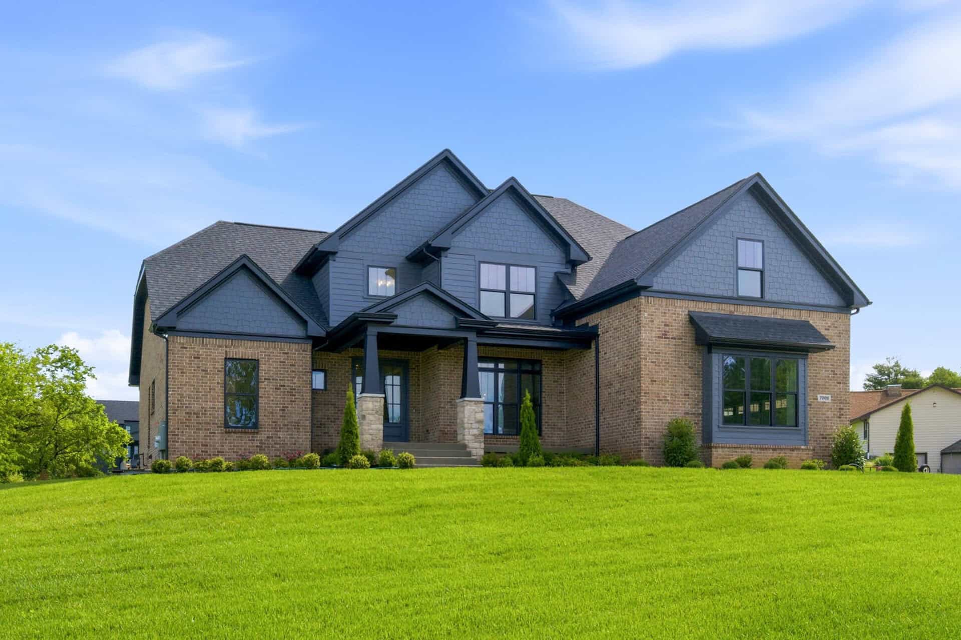 Modern luxury home with blue siding and brick accents in Kentucky.