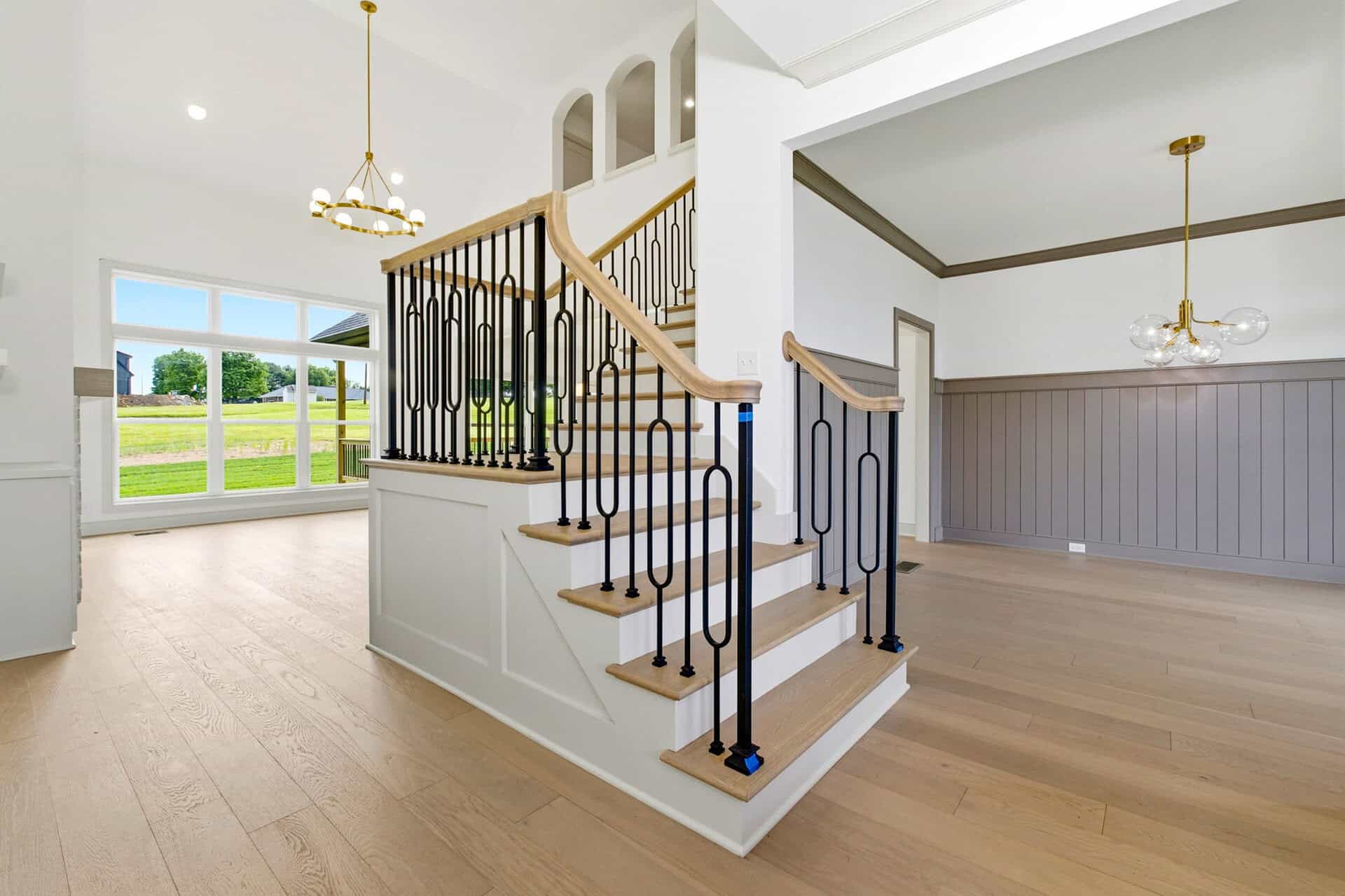 Bright interior with staircase and large windows in a luxury home.