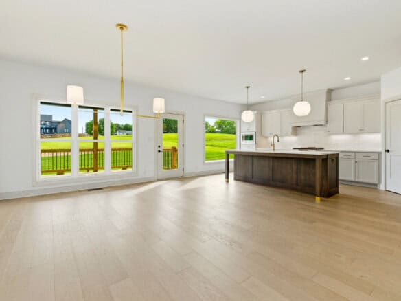Spacious open-concept kitchen and living area with large windows and modern lighting.