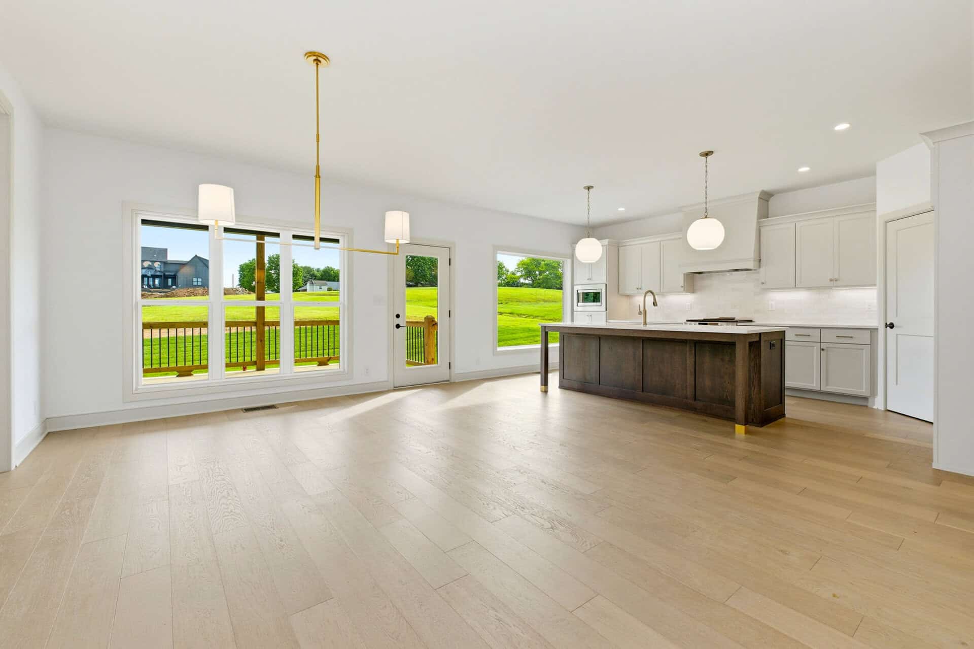 Spacious open-concept kitchen and living area with large windows and modern lighting.