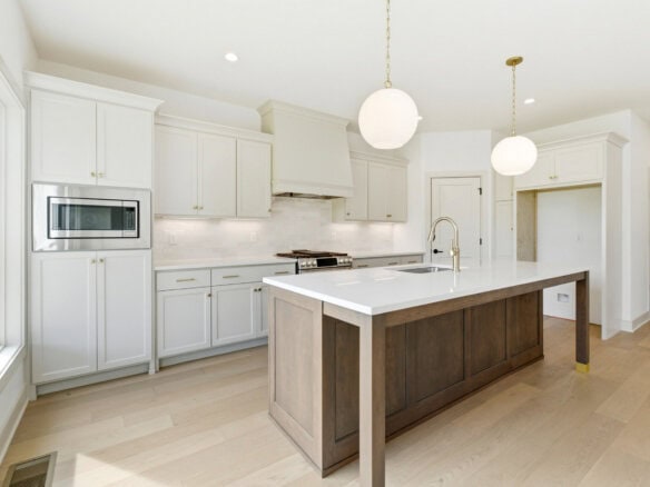 Modern kitchen with white cabinets, island, and pendant lighting.