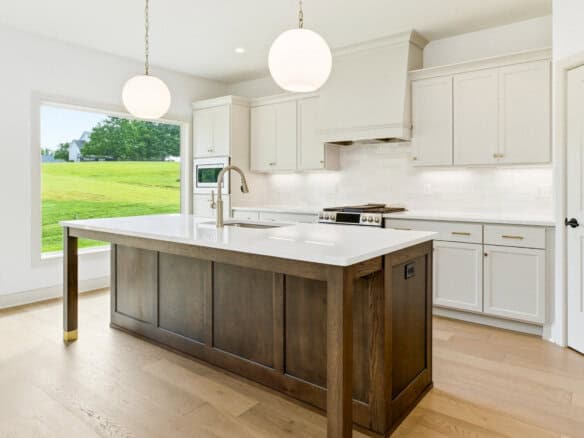 Modern kitchen with white cabinets and a dark island in a new home.