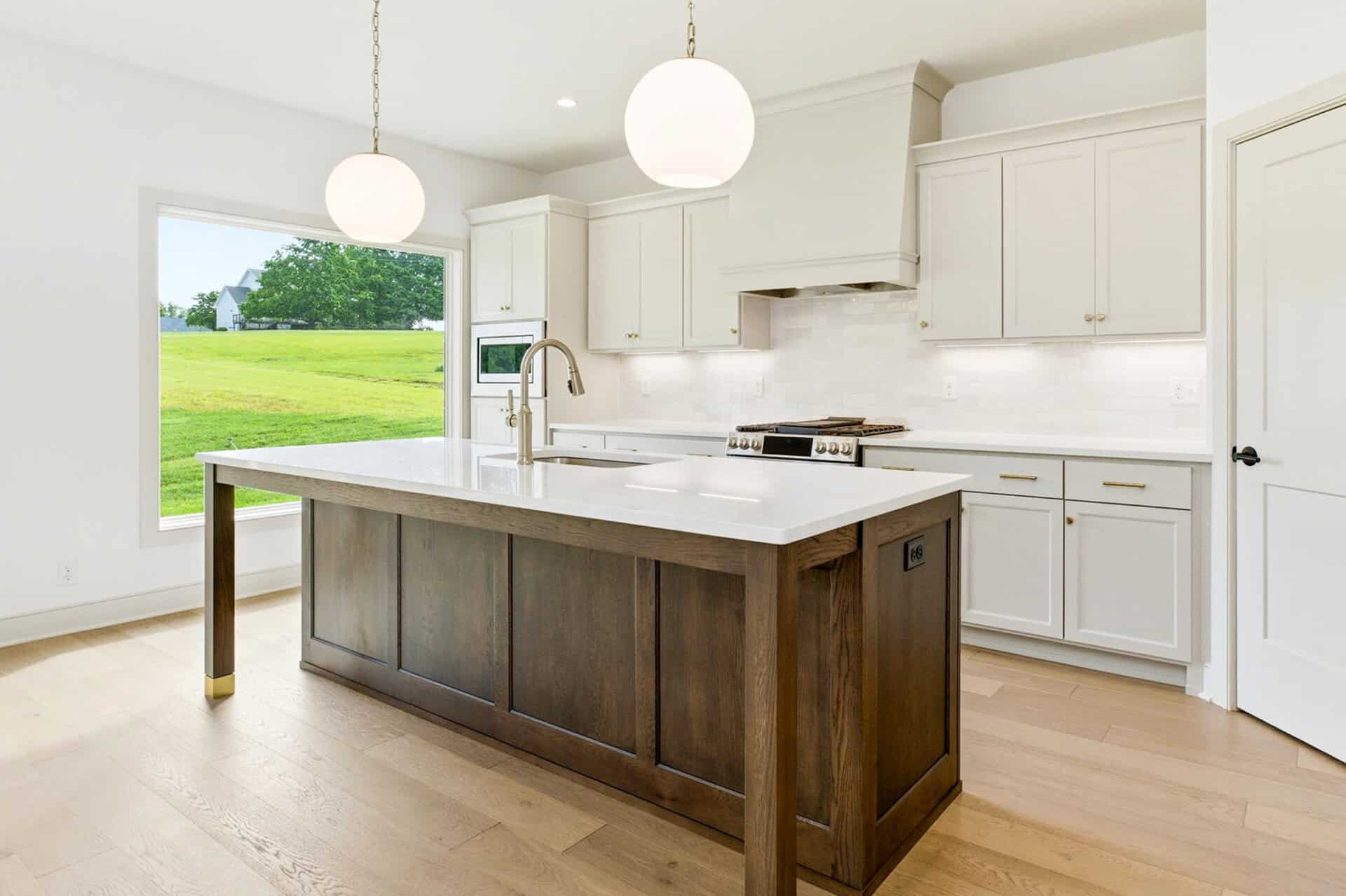 Modern kitchen with white cabinets and a dark island in a new home.