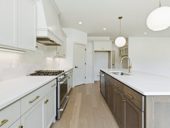 Modern kitchen with white cabinets, island, and high-end finishes.