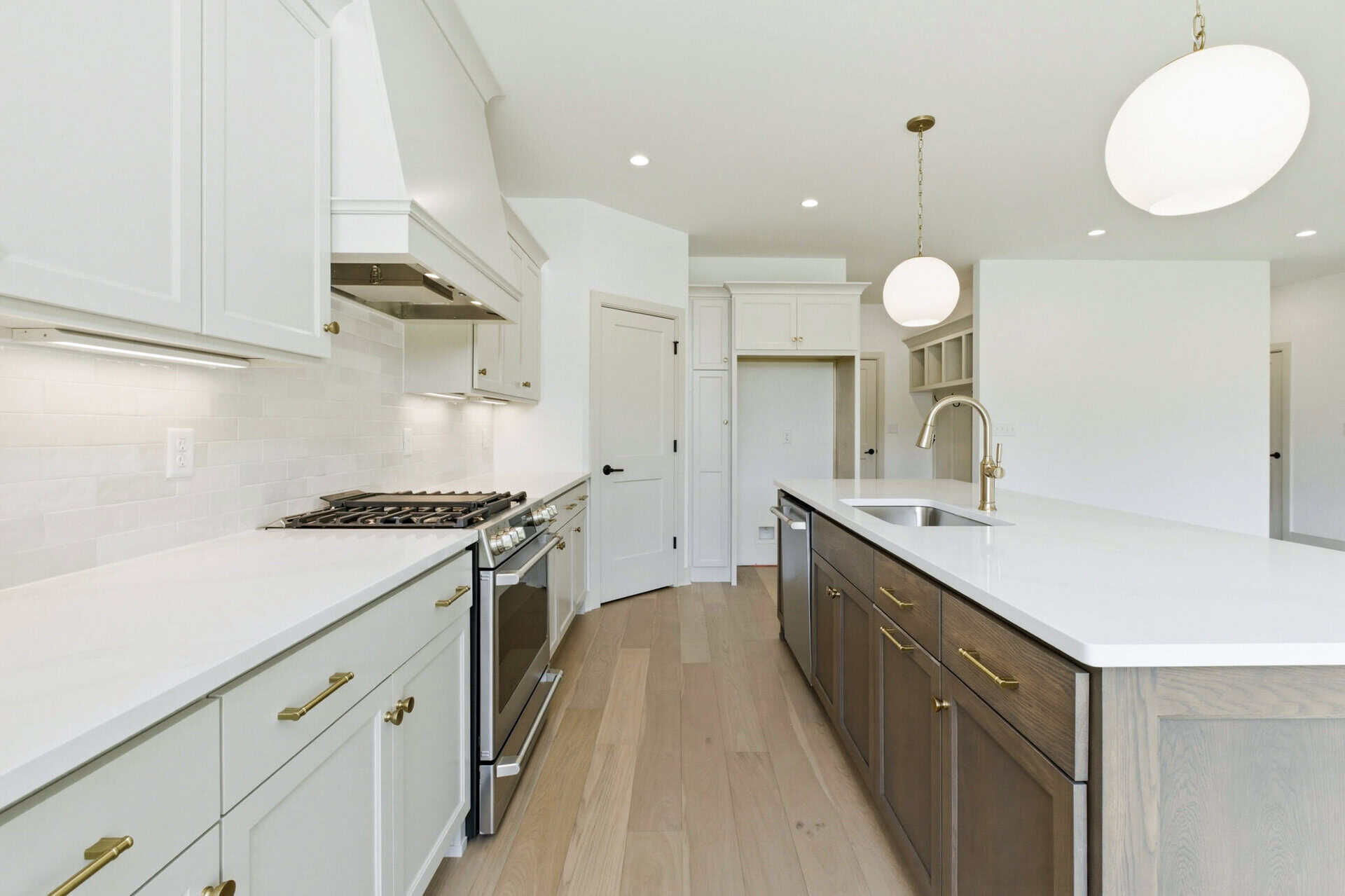 Modern kitchen with white cabinets, island, and high-end finishes.