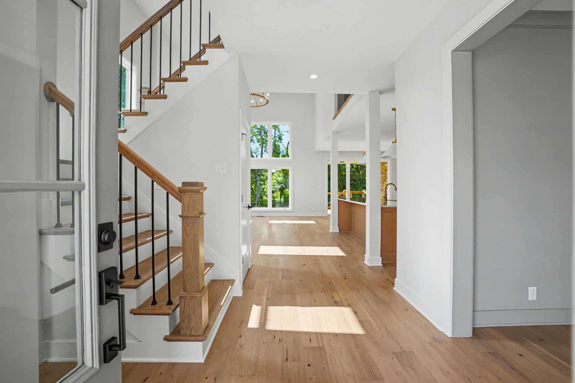 Bright, open interior with hardwood floors and staircase at Mason Construction & Development.