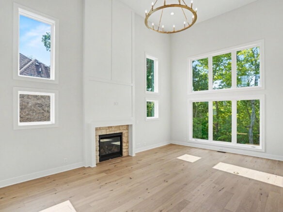 Bright living room with large windows and a modern fireplace.
