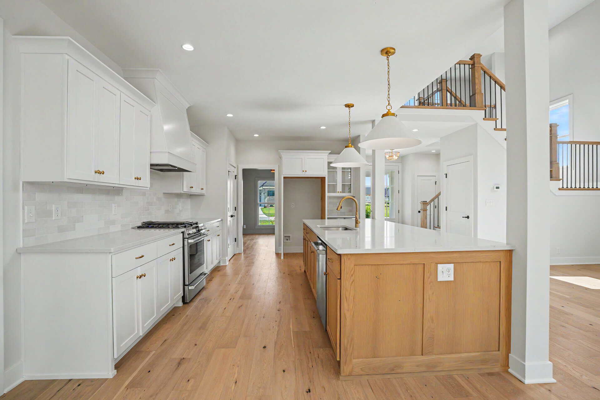 Modern white kitchen with island and high ceilings in Louisville home.