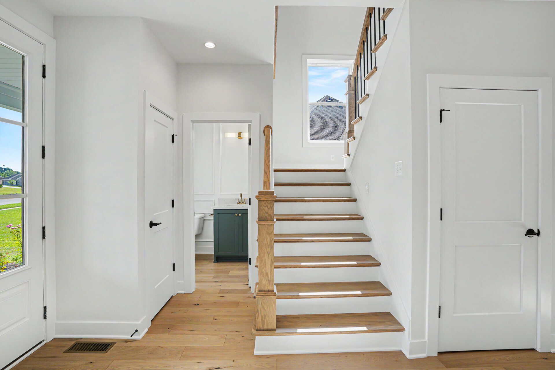Bright entryway with staircase and natural light in a modern home.