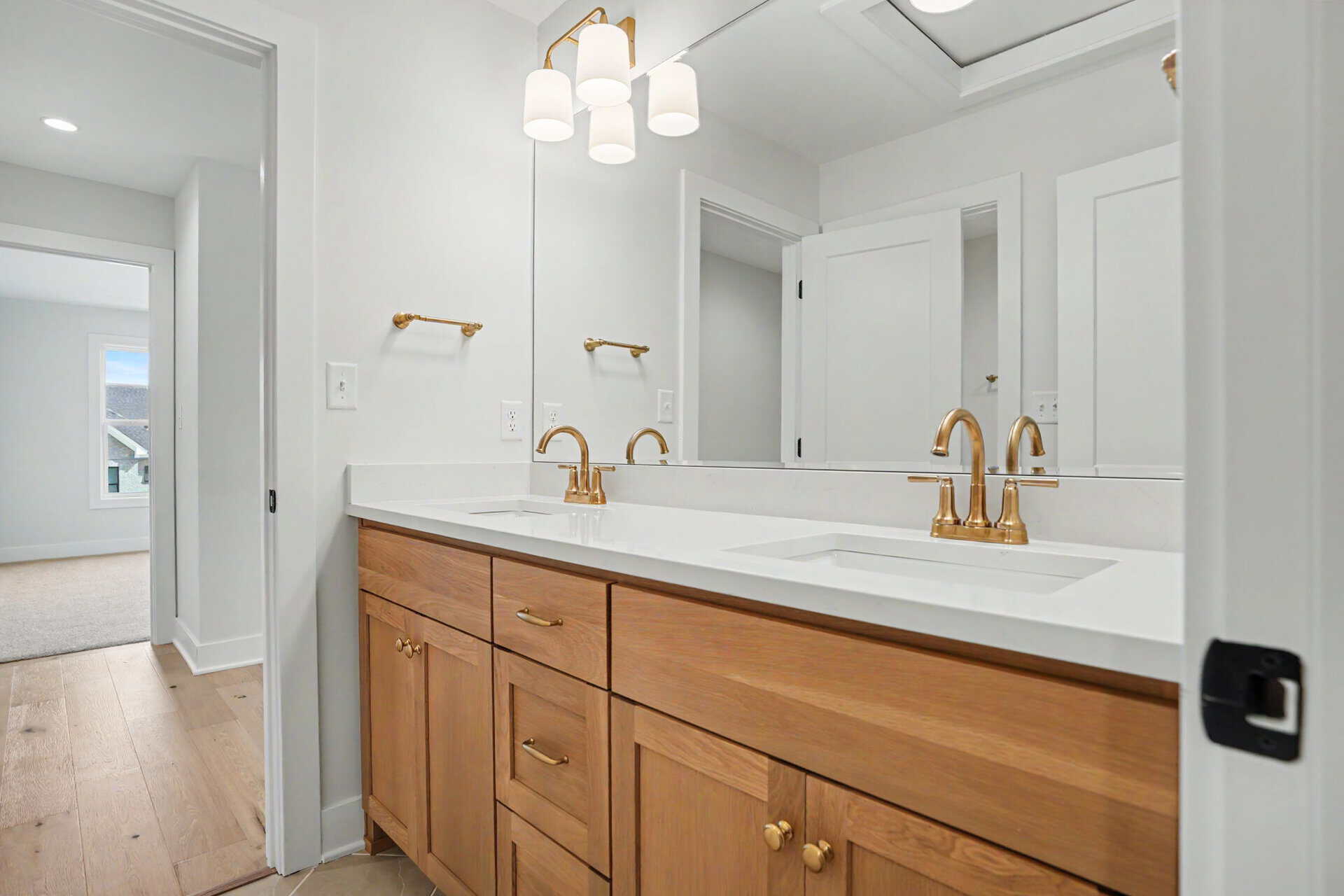 Modern bathroom vanity with double sinks and gold fixtures in a bright space.