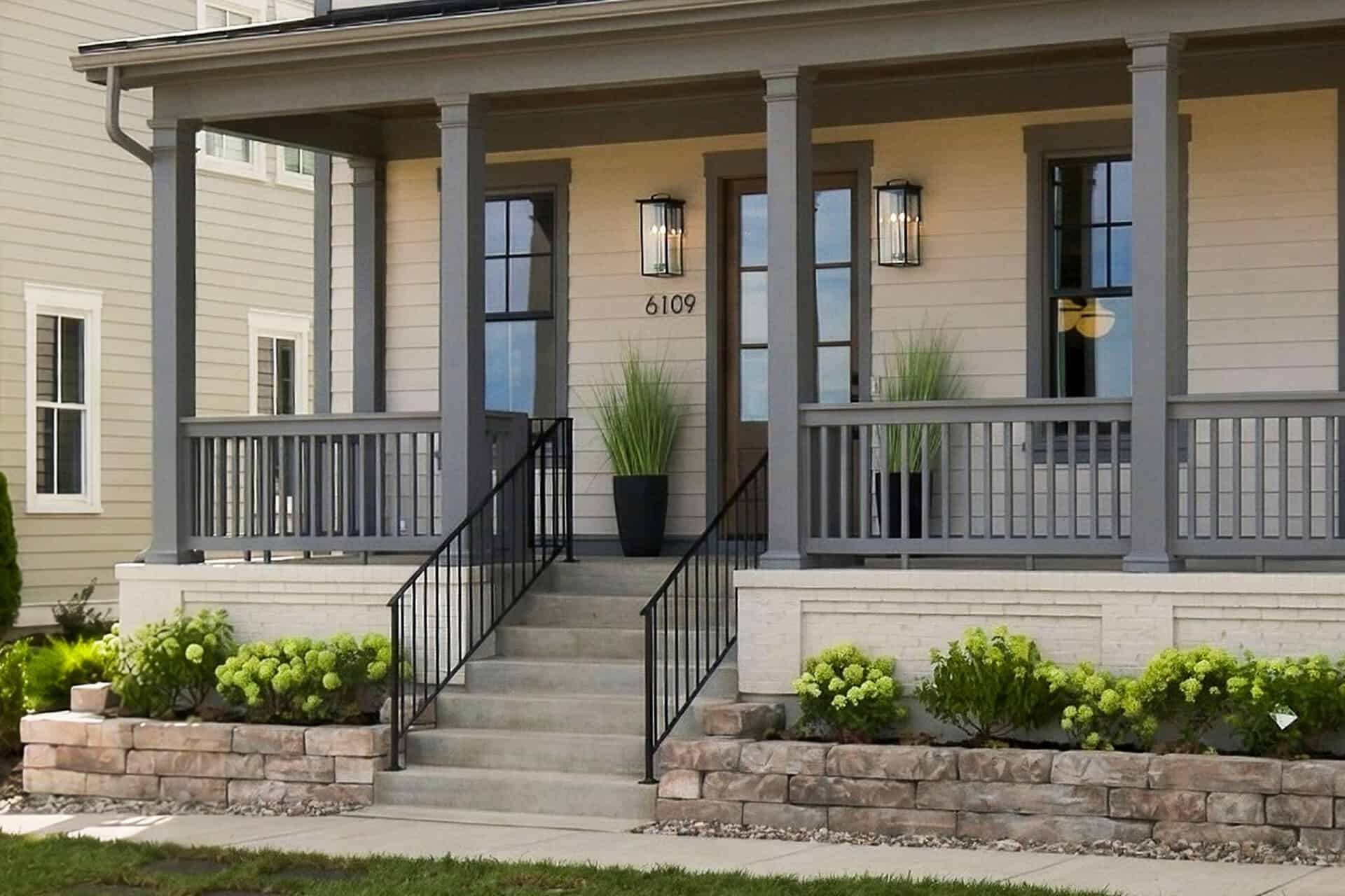 Front porch on a beige house with gray trim, columns, lantern lights, and the number 6109 by the door