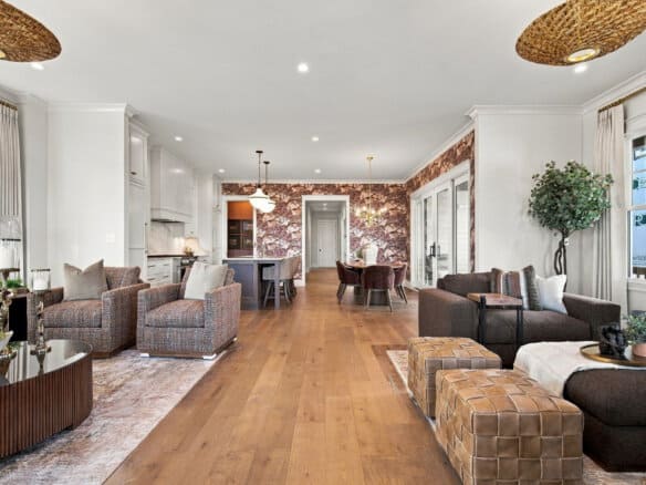 Spacious modern living room with hardwood floors, large windows, and stylish furniture.