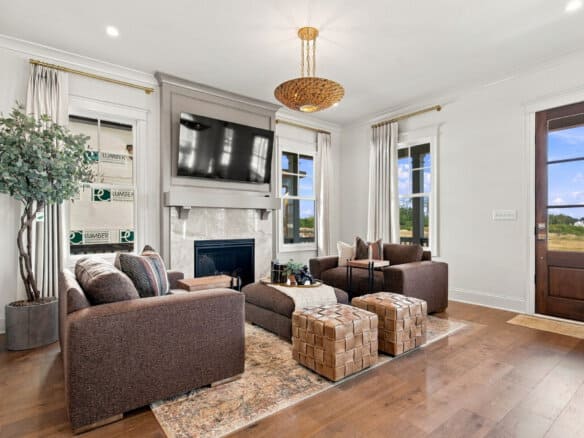 Modern living room with fireplace, large windows, and stylish furniture.