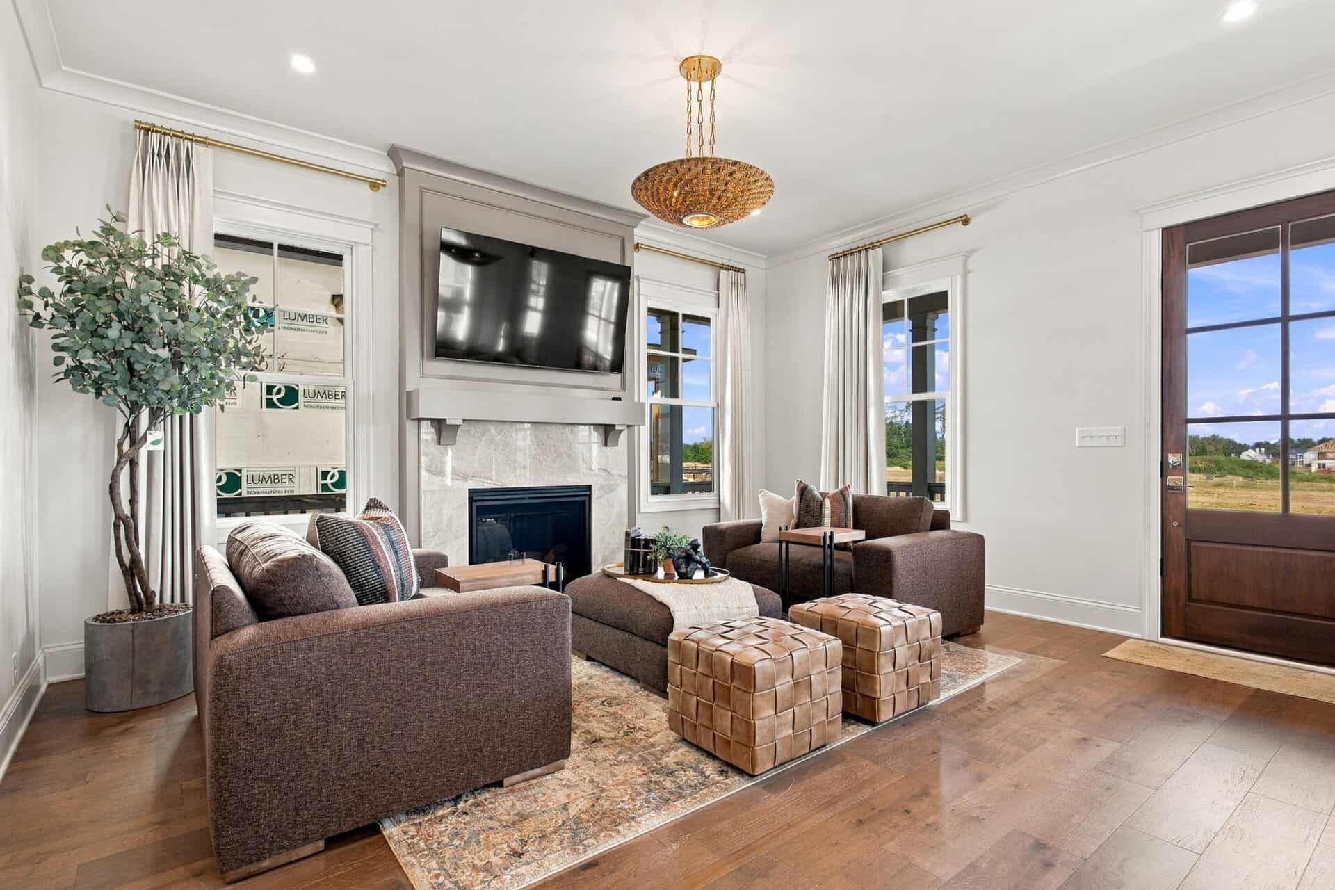 Modern living room with fireplace, large windows, and stylish furniture.