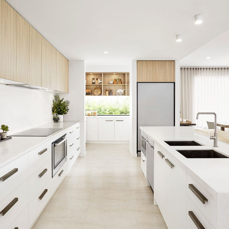 Modern minimalist kitchen with white cabinets and natural wood accents.